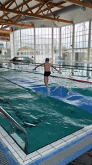 Boy attempts to run across inflatable mat in French pool