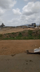 Goat herd gathers near trucks in rural Nigeria