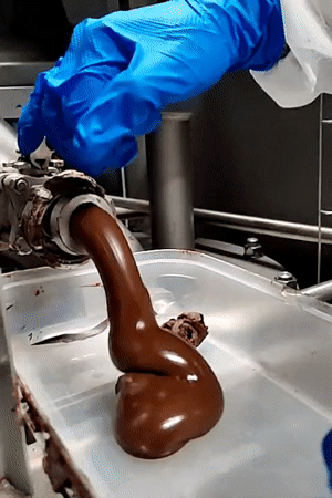 Lab worker fills container with chocolate from tube