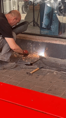 Welder installs metal plate on Tel Aviv sidewalk
