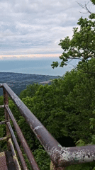 Tourist photographs coastal views from rusted observation platform in Abkhazia
