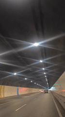 Vehicle travels through grid-lit tunnel with starburst lighting effects