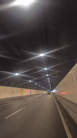 Vehicle travels through grid-lit tunnel with starburst lighting effects