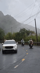 White SUV travels misty mountain road in Vietnam