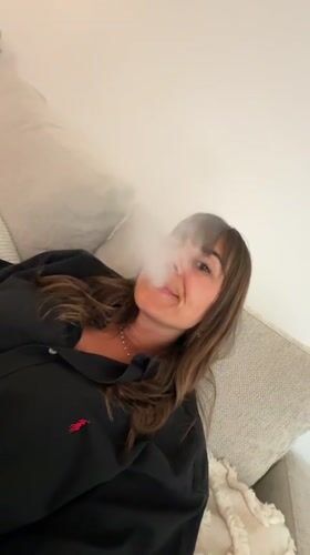 Woman relaxing, vaping at home meal in Cannes