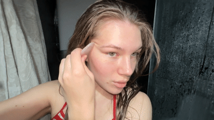 Woman performs morning gua sha facial routine in Belgrade bathroom