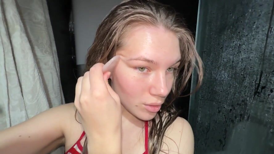 Woman performs morning gua sha facial routine in Belgrade bathroom
