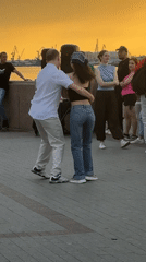 Couples dance in an Astrakhan plaza at golden hour
