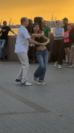 Couples dance in an Astrakhan plaza at golden hour