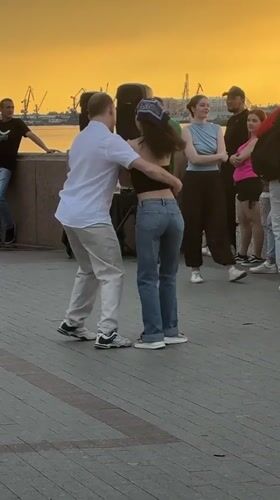 Couples dance in an Astrakhan plaza at golden hour