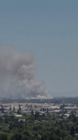 Heavy smoke plume rises over Sacramento skyline in clear conditions