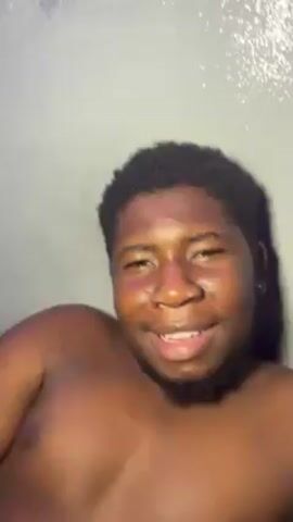 A person is shown in bed, talking on a cell phone and smiling. They are lying down under a gray blanket with white circles. There is a blue light in the room. The person brings the phone down to their chin before the video ends.