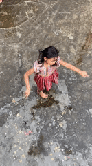 Kids play in the rain across a flooded Dhaka rooftop