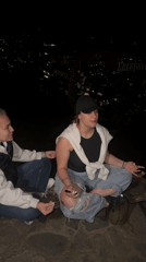 Two women meditate overlooking Kyustendil city lights at night