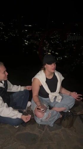 Two women meditate overlooking Kyustendil city lights at night