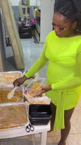 Woman prepares food in tiled kitchen, Kuchingoro Nigeria