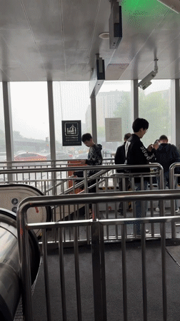 Early morning commuters shelter from rain at Beijing subway station