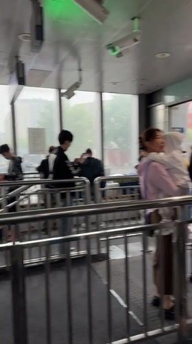 Early morning commuters shelter from rain at Beijing subway station