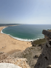 Busy afternoon at Nazaré beach captured from clifftop viewpoints