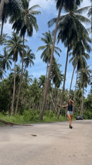 Woman walks palm-lined roads in Thai village