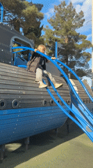 Child plays on ship playground, caterpillar observed in palm