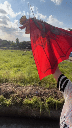 Person flies dragon kite on brick path in Kediri