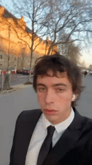 Formally dressed man walks through Paris streets