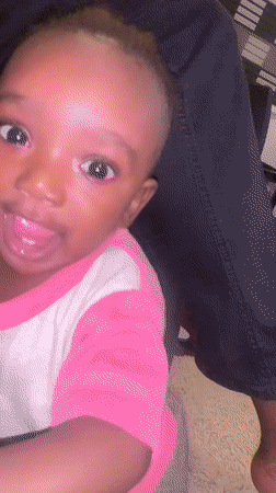 Close-up portrait of a baby in pink and white shirt