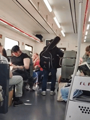 Street musician performs guitar aboard moving train in Mataró