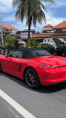 Red Porsche, delivery rider share busy Denpasar street scene
