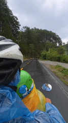 Motorcycle riders navigate wet roads during rainy weather Vietnam