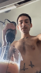 Tattooed person makes fruit smoothie in Buenos Aires kitchen