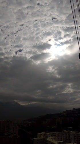 Caracas hillside neighborhoods documented under cloudy afternoon skies