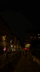 Paris streets after dark, buildings glowing on a summer night.