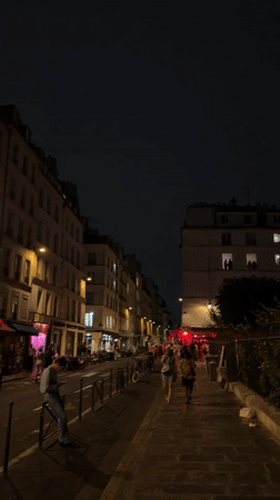 Paris streets after dark, buildings glowing on a summer night.