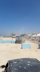 Activity among Gaza rubble: machinery and a street gathering
