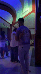 Couples slow dance under colorful lights at Pattaya party