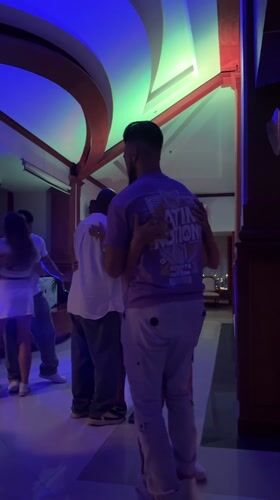 Couples slow dance under colorful lights at Pattaya party