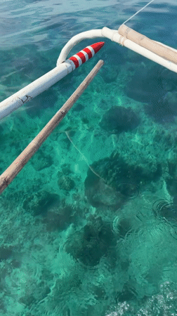 Yellow boat cruises clear waters near General Luna, Philippines