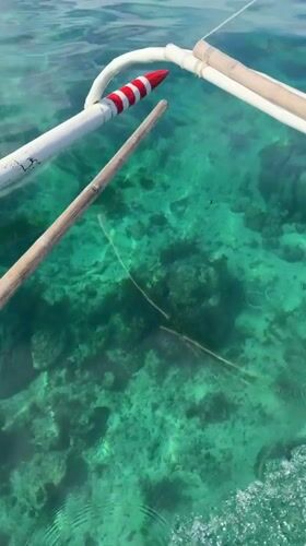 Yellow boat cruises clear waters near General Luna, Philippines