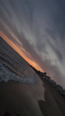 Dusk at Quarteira's rocky shore, moon rising over the Atlantic