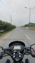 Motorcyclist travels Honda through Dhaka streets alongside river