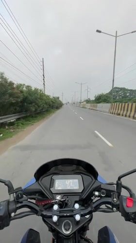 Motorcyclist travels Honda through Dhaka streets alongside river