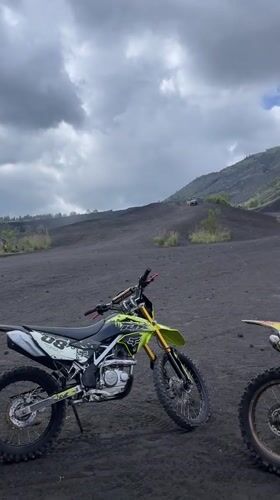Dirt bikers gather on volcanic terrain in Kintamani