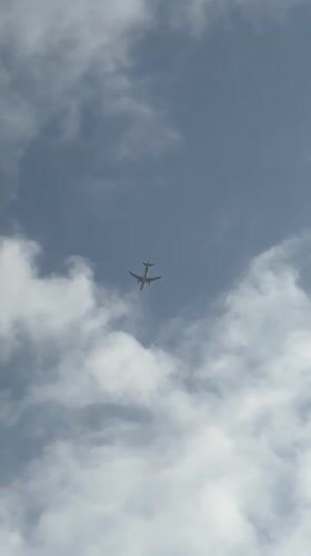 Commercial flight passing through cloudy skies over Karachi