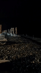 Late-night drinks and moonlight on a Sirius pebble beach.