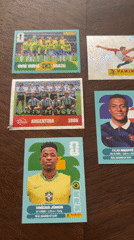 FIFA World Cup sticker cards displayed on wooden surface