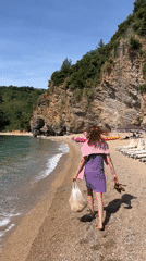 Woman enjoys morning beach walk in Budva, Montenegro