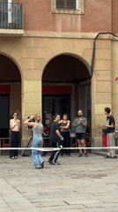 Morning scenes documented across Barcelona include queues, sneakers, street performers