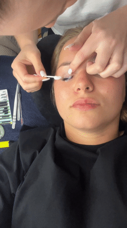 Black cat yawns near blue structure in Budva